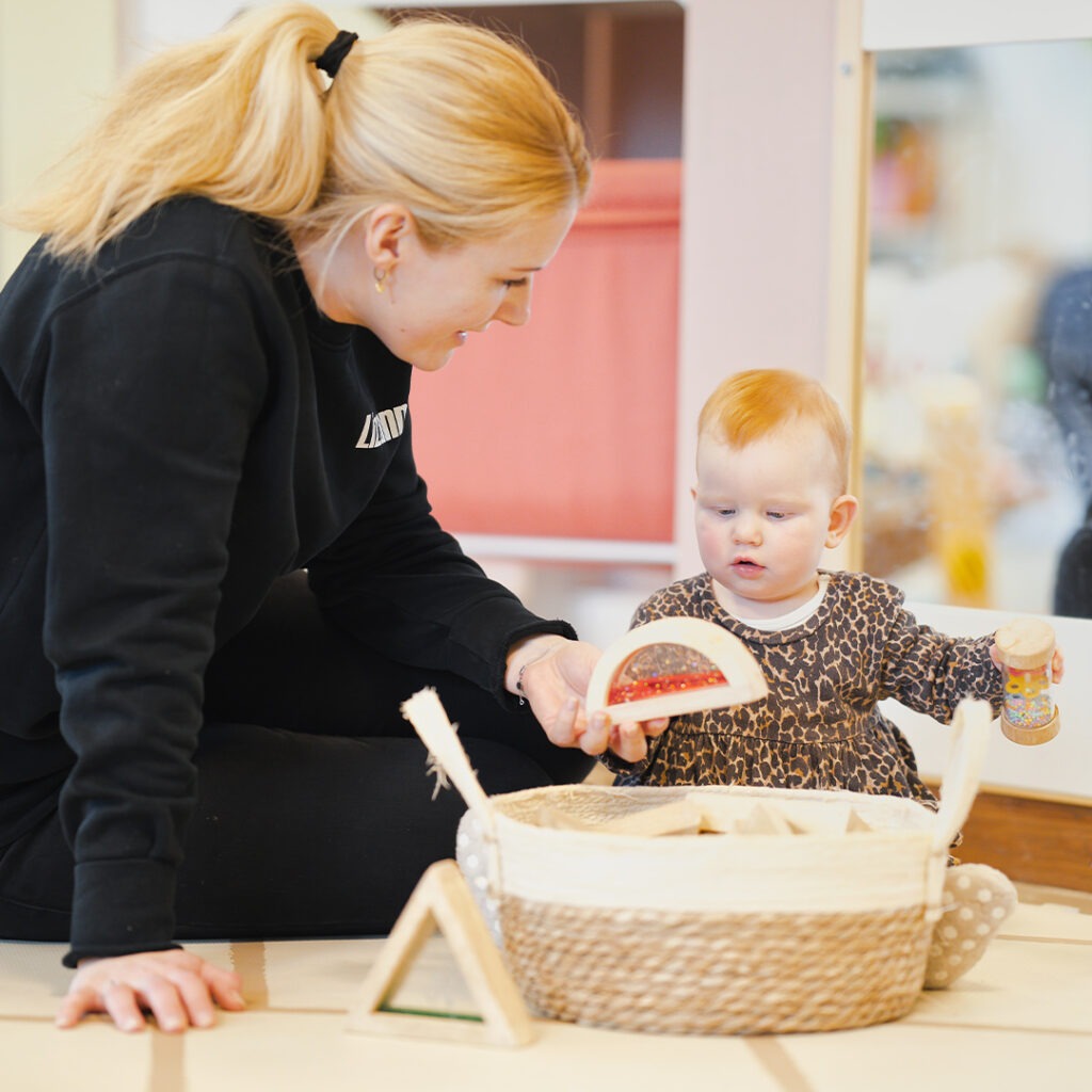 Pedagogisch medewerker van Kids Lodge speelt met baby