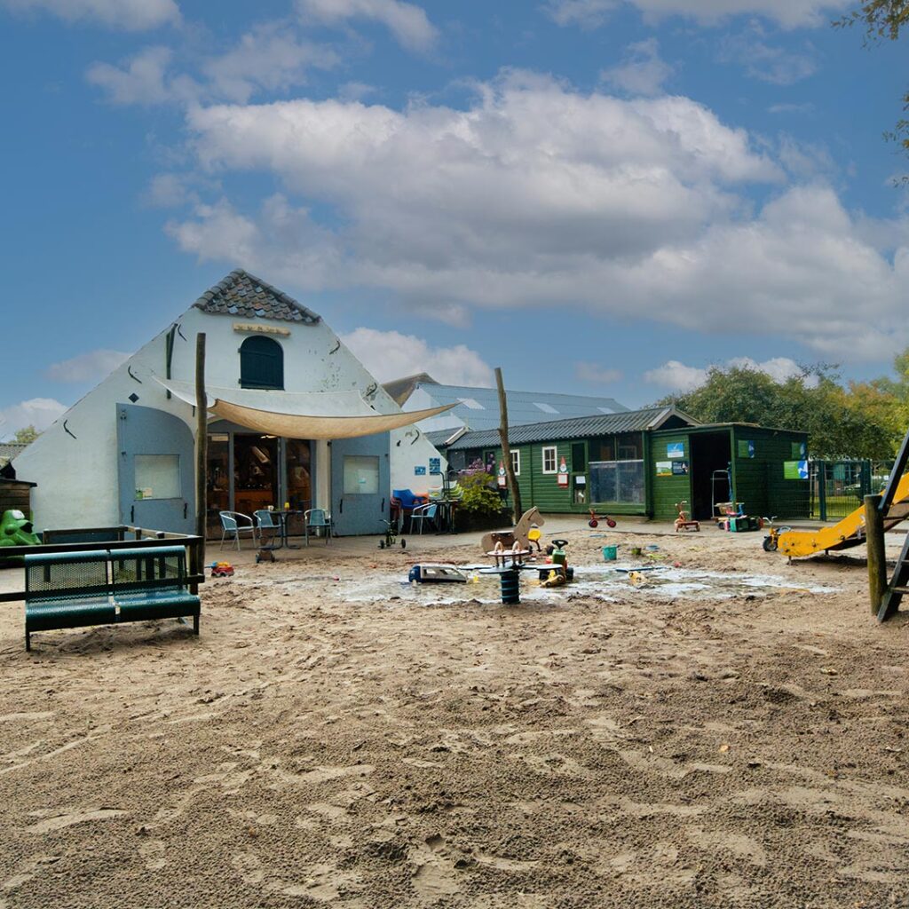 Buitenspeelplaats met veel zand en glijbaan bij locatie Kinderboerderij in Driebergen