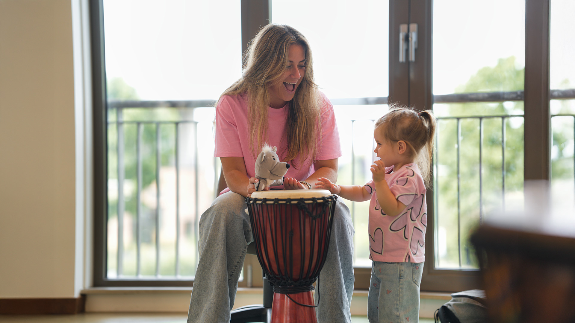 Pedagogisch medewerker van Kids Lodge maakt muziek met peuter