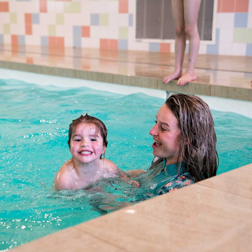 Moeder en kind zijn blij in het water van het zwembad in Houten