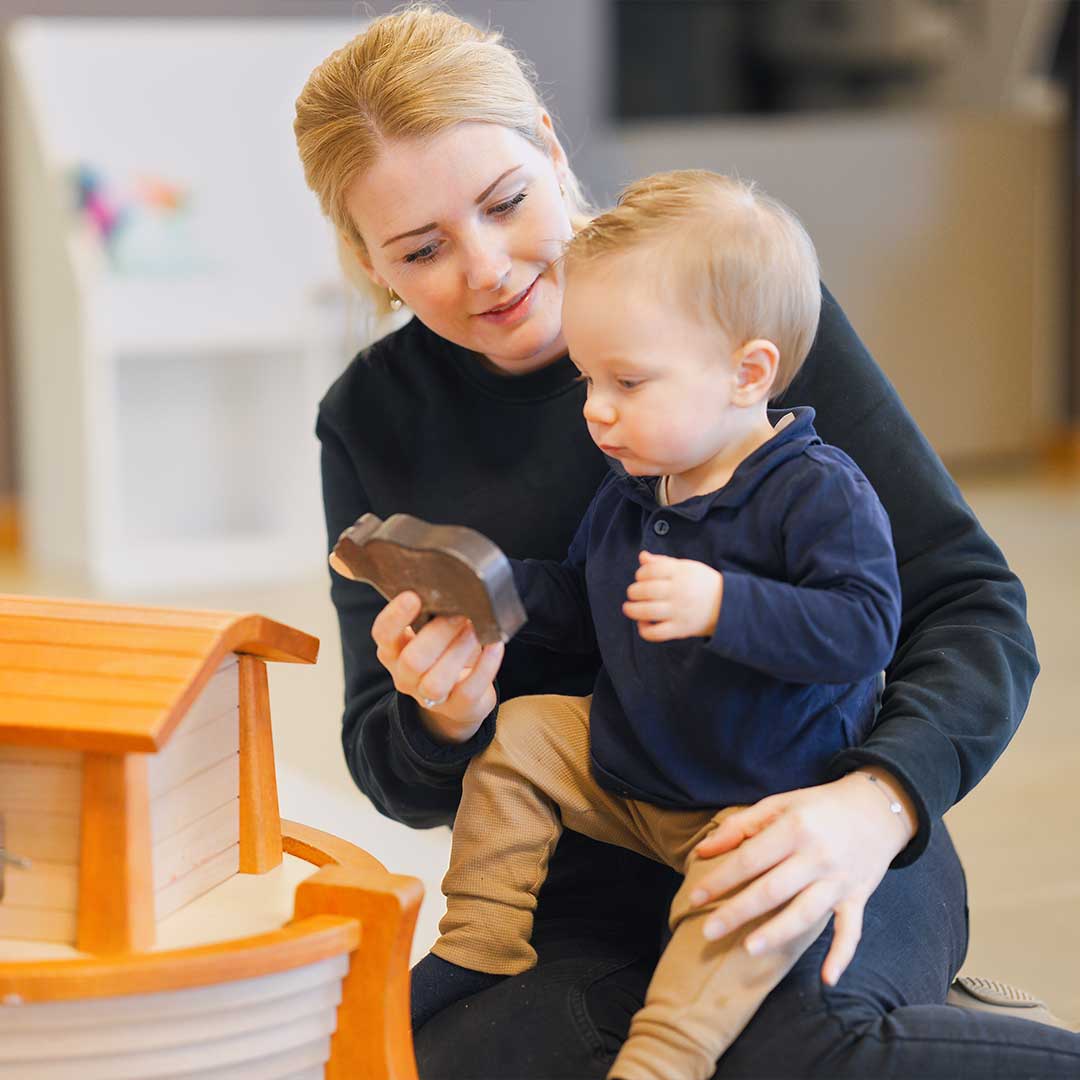 Pedagogisch medewerker van Kids Lodge speelt met baby