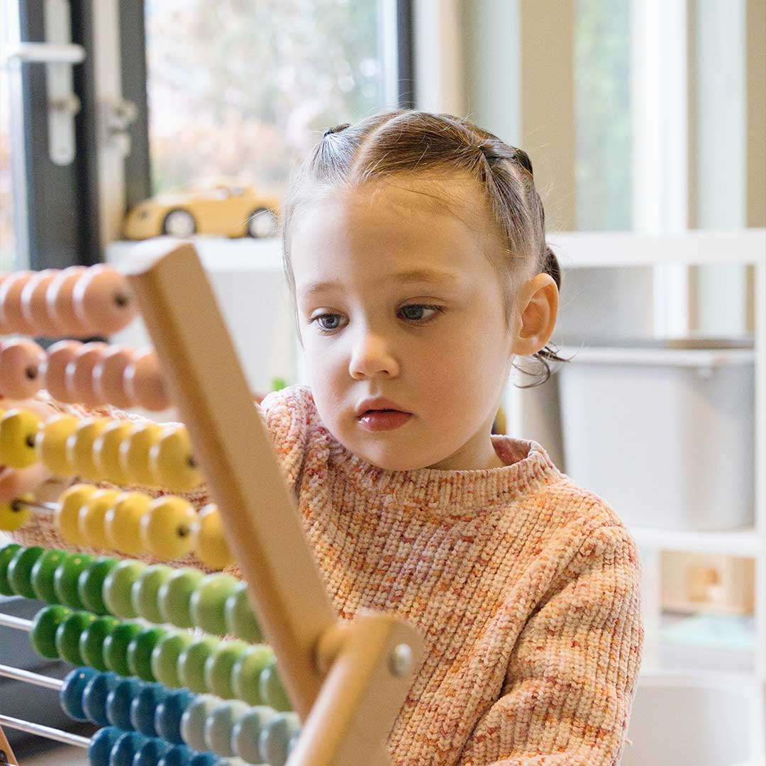 Kindje leert tellen met telraam op kinderopvang