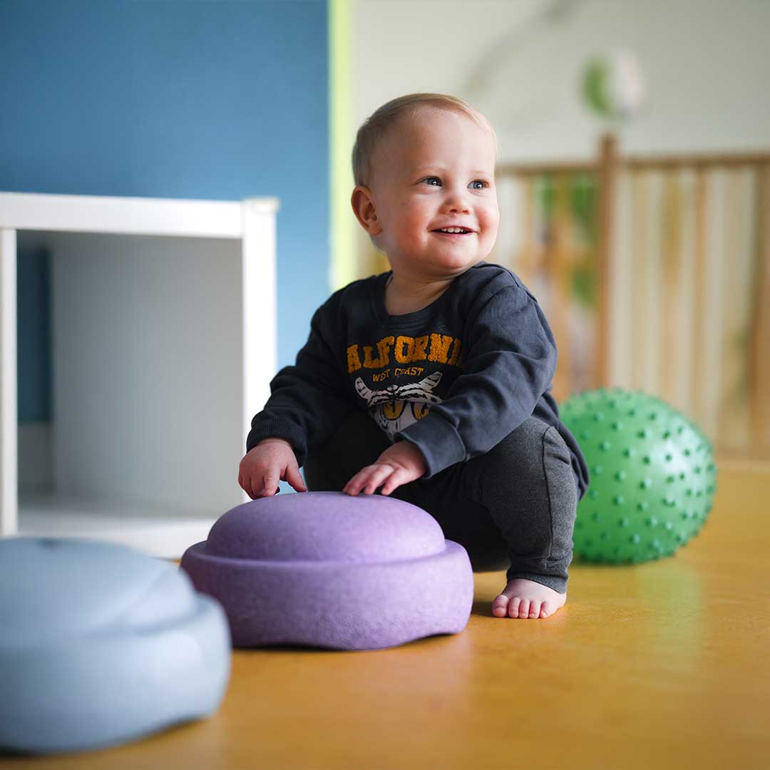Vrolijke baby speelt bij kinderopvang Kids Lodge