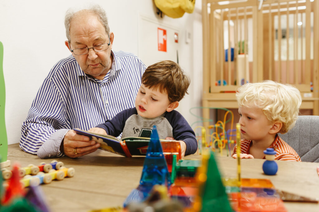 Rustig voorlees moment, man leest een boek aan twee kinderen
