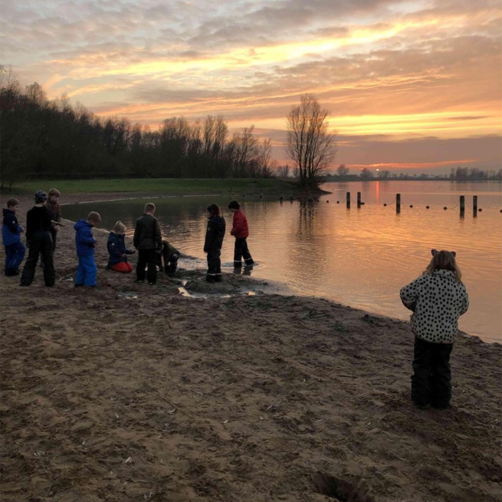 Spelen met zand en water langs de rand van een meer bij locatie Bruininxdeelsekade in Leerdam