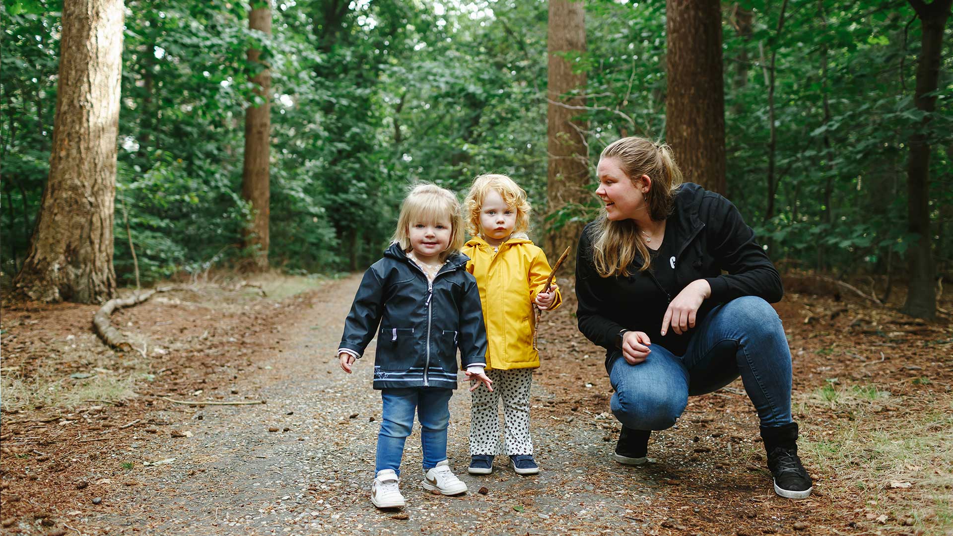 Kids Lodge medewerker wandelt in het bos met kinderen