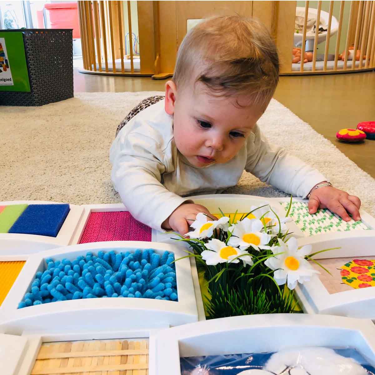 Sensorische activiteit bij kinderopvang KidsLodge, baby voelt aan materialen