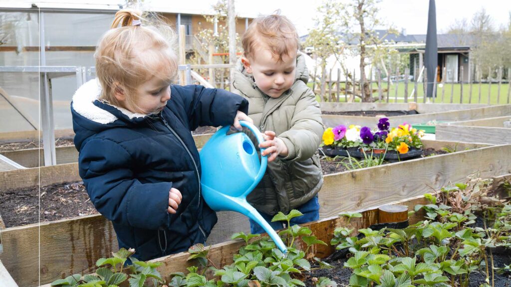 Peuters geven plantjes water bij kinderopvang Kids Lodge
